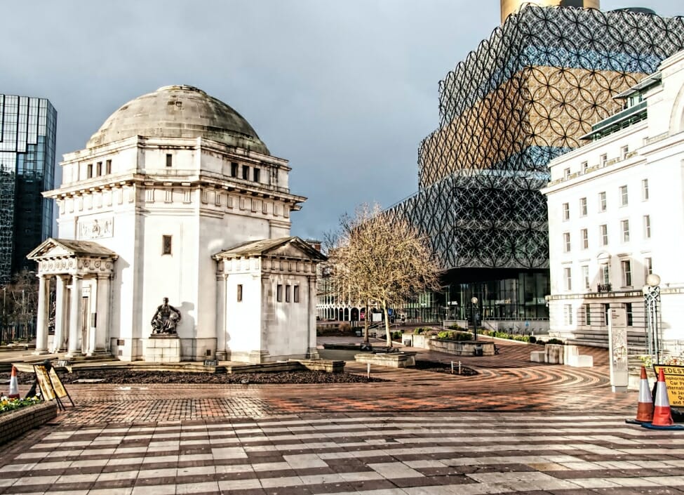Birmingham Library in the background with a dome building in the foreground and a tiled pavement