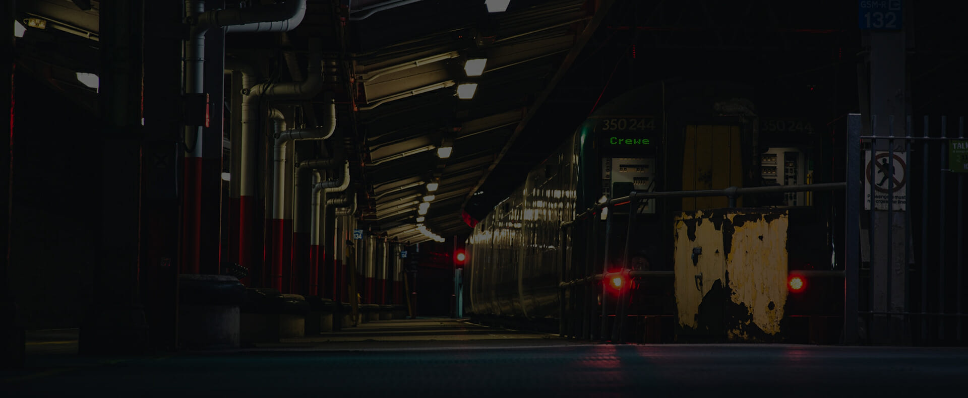 train waiting at platform at crewe train station at night with red lights