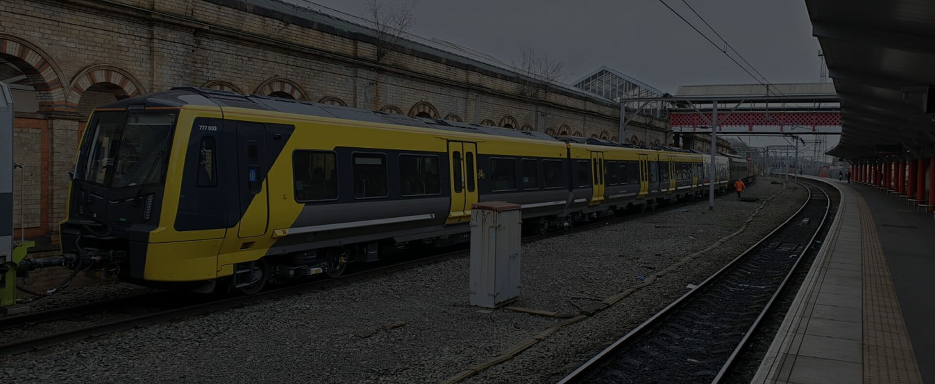 merseyrail liverpool yellow train at empty platform with footbridge overhead