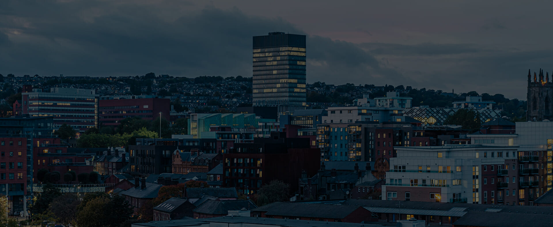 aerial view of Sheffield city at night with a tall block of flats and other buildings