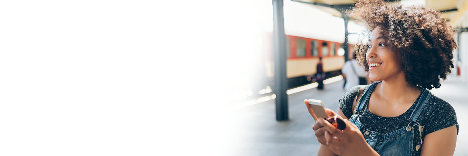 a cheerful woman searches for train tickets on her phone