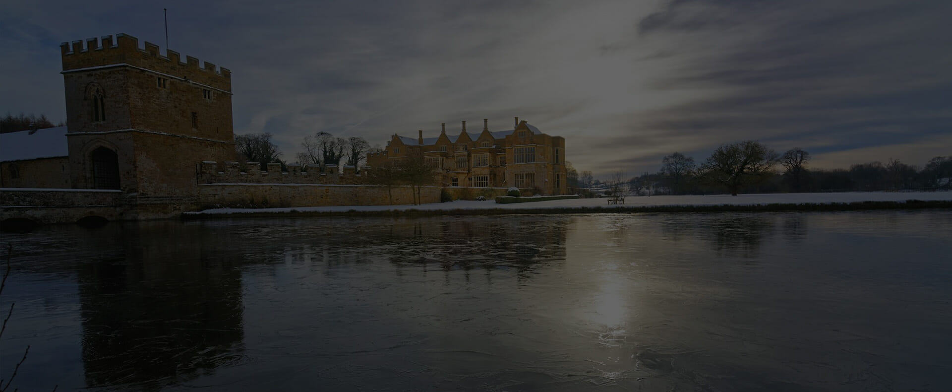 banbury broughton castle next to lake during winter with cloudy sky