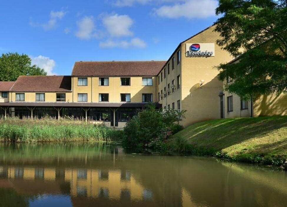 Bath Travelodge Waterside Hotel by the River Avon with bushes and grass outside