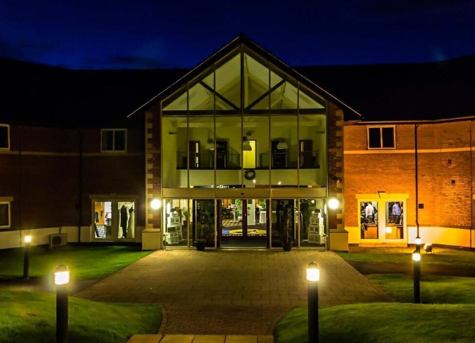 Padbrook Park Hotel Tiverton entrance lit up at night with grass surrounding