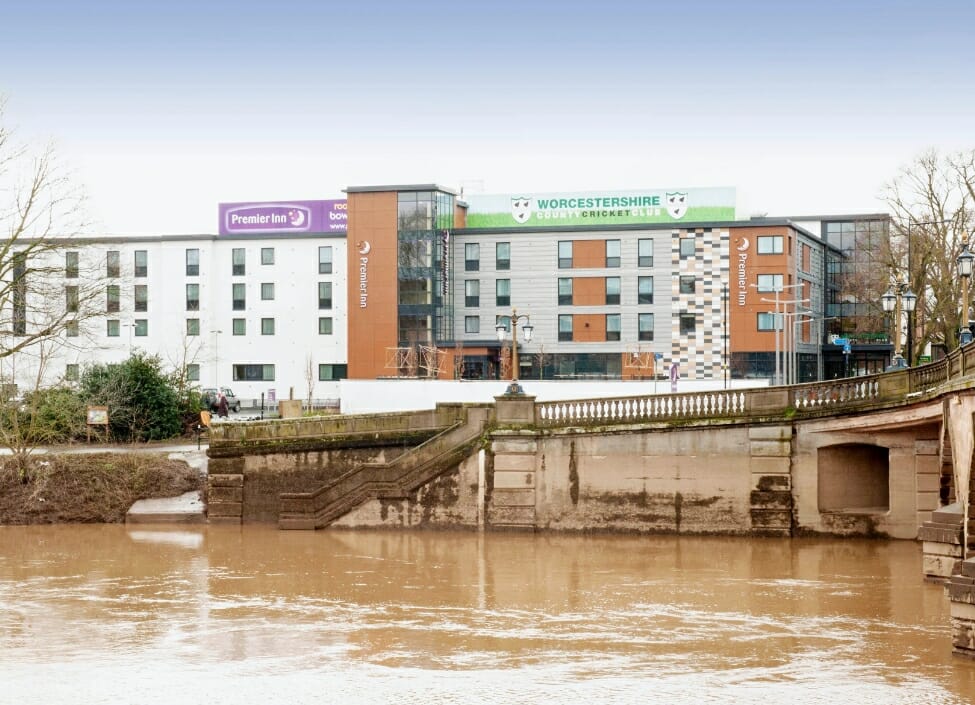 Worcester City Premier Inn Hotel white building with windows during the day in front of river severn with a bridge