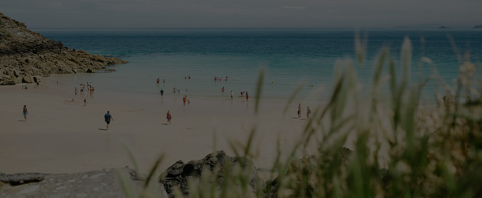 st ives beach with people walking on the sand and swimming in the sea