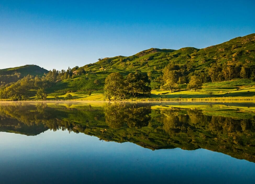 lake district rydal water near ambleside with trees and hills reflecting on to the water
