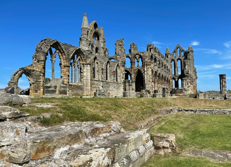 whitby abbey made of stone with blue sky and grassy areas