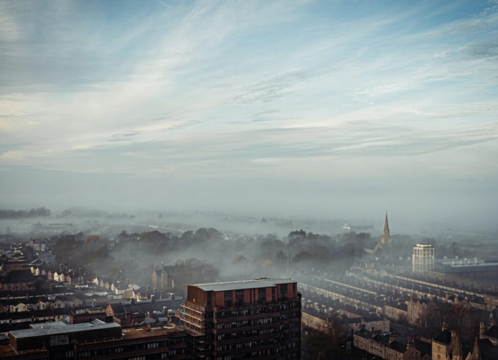 swindon town aerial view with mist buildings trees and a cloudy sky