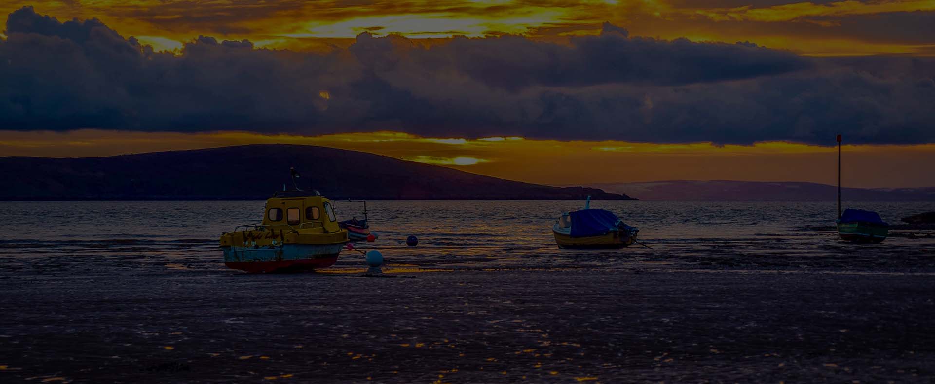 weston super mare bristol channel with boats in sea sunset and mountain in background