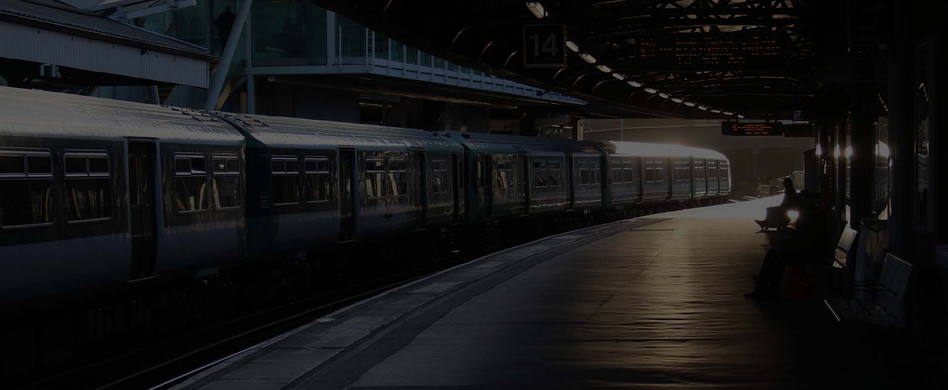 clapham junction station london with a train waiting at the platform and a person sat down