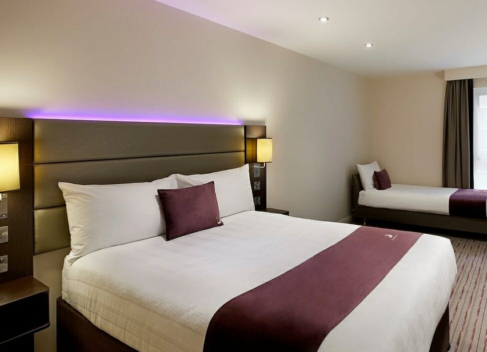 Premier Inn Derby City Centre hotel room with a double bed, single bed, and desk