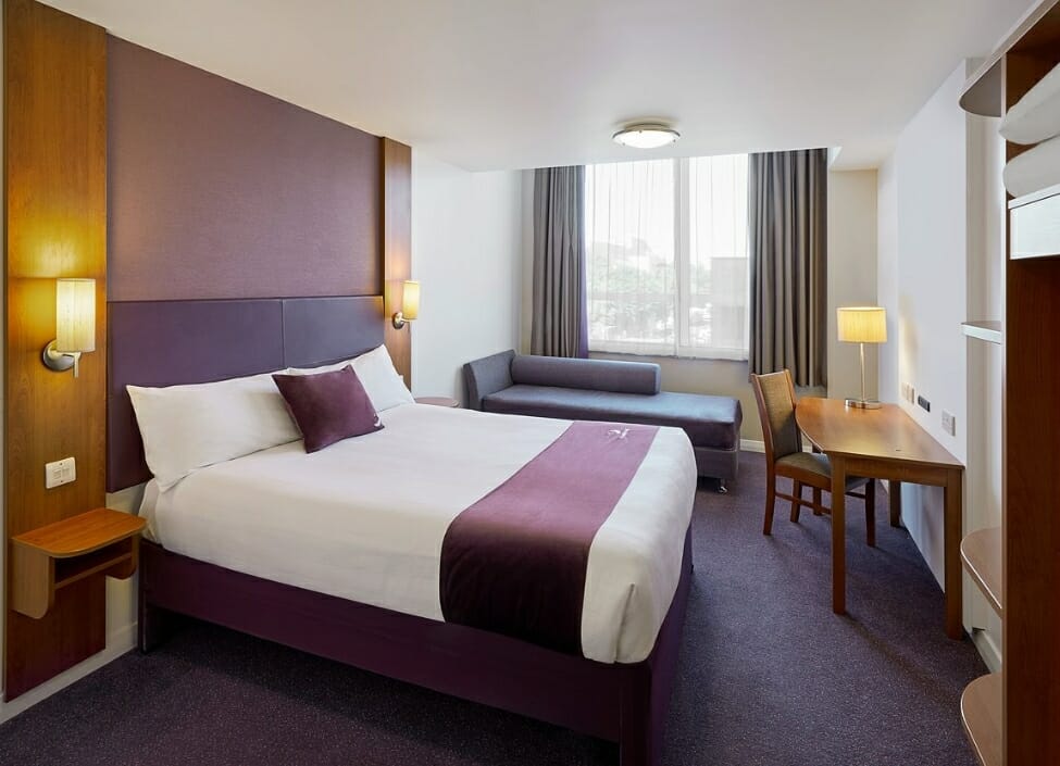 A Premier Inn Leicester City Centre Hotel room with bed, sofa, and desk