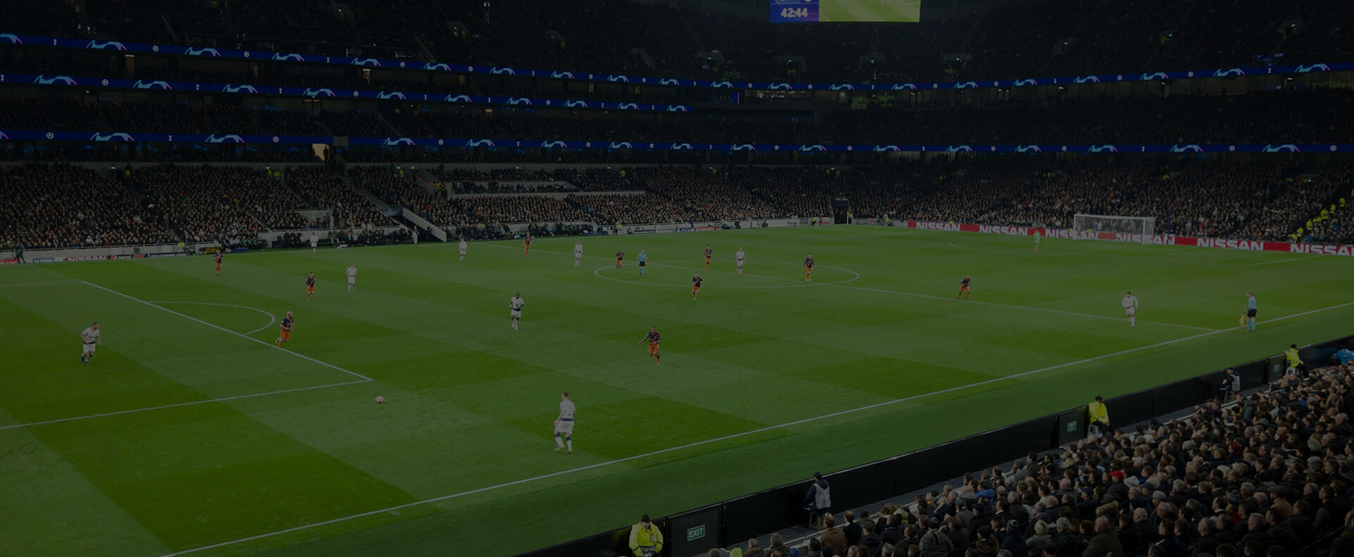 tottenham hotsput stadium at night with teams playing football and fans in the stands