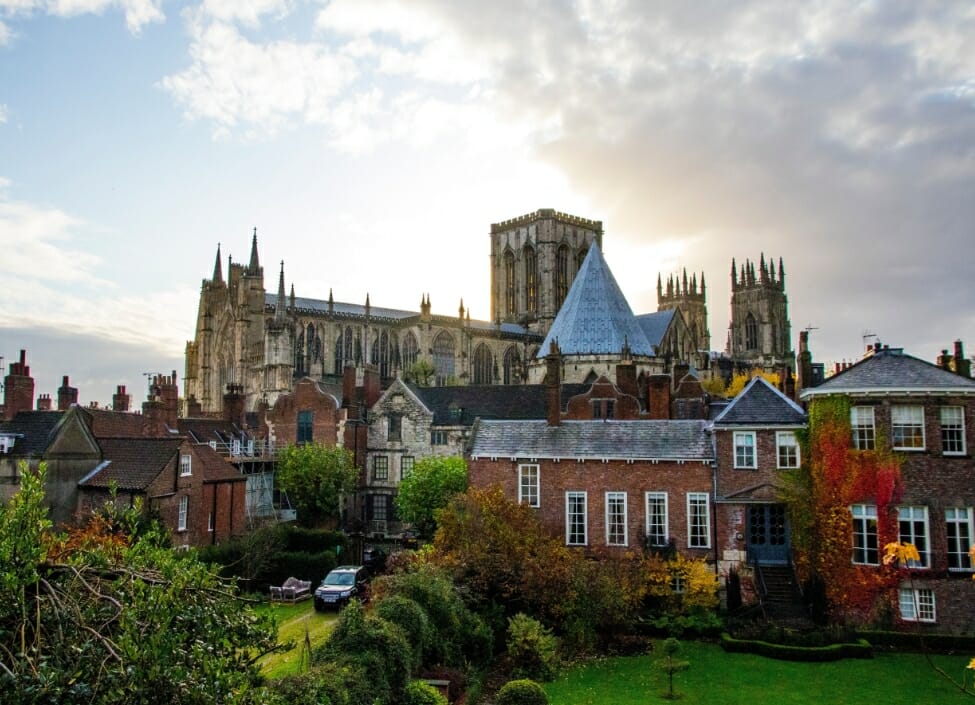 York City Minster in the City of York with red-bricked houses and gardens in front.