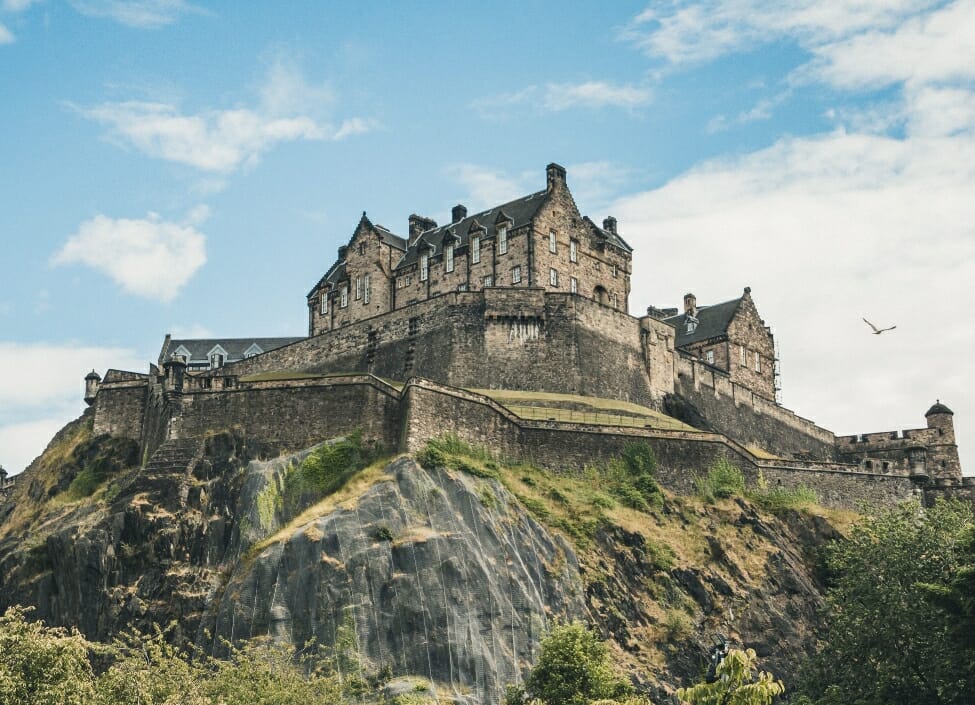 Edinburgh Castle on top of a hill, an old building with a cloudy sky in the background