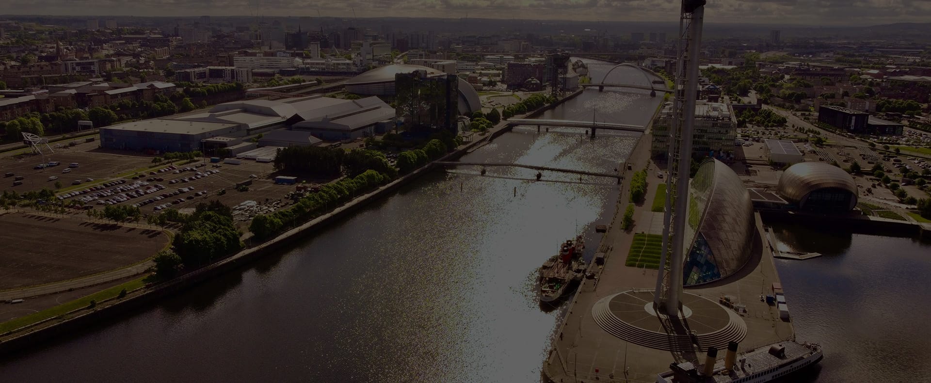 Aerial view of the River Clyde in Glasgow with Science City, other buildings, and bridges