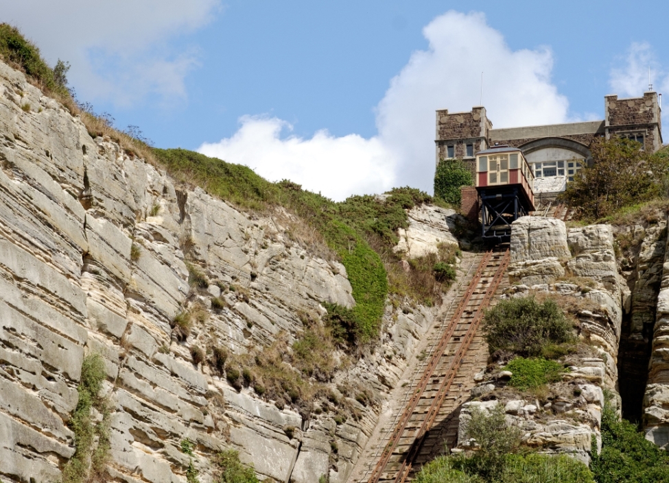 A train on a hill to a station on the East Hill Cliff Railway in Hastings, with rocks on each side